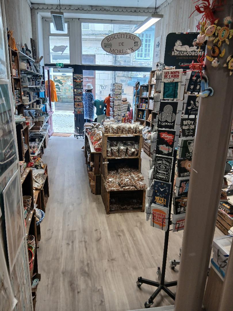 Implanté depuis près de 15 ans, ce commerce bénéficie d'une excellente visibilité grâce à son emplacement stratégique sur un axe de passage majeur du centre-ville. Le magasin profite d'un environnement commercial très dynamique, à proximité immédiate de nombreux commerces, services, et de la mairie.

L'activité est spécialisée dans la vente de produits régionaux bretons : biscuiterie, épicerie fine, souvenirs, décoration et textiles bretons notamment. L'enseigne s'appuie sur une clientèle fidèle locale tout en bénéficiant d'une forte attractivité touristique. Plus d'un tiers du chiffre d'affaires est réalisé durant la saison estivale, principalement sur les mois de juillet et août, grâce à des produits d’appels attractifs : caramels bretons, bols bretons traditionnels ou encore des boîtes de biscuits locaux personnalisées.

Le local, d’une surface totale d'environ 130 m² répartie sur deux niveaux, dispose d’un atout rare : deux accès indépendants sur deux rues différentes, dont l’une est un axe routier stratégique du centre-ville. Le local se répartit entre :

100 m² de surface commerciale en rez-de-chaussée, avec de belles vitrines ;
Et environ 30 m² de réserve et bureau.
Le commerce dispose également d'un site e-commerce opérationnel, permettant de développer les ventes à distance et de fidéliser la clientèle au-delà de la zone de chalandise locale.

L'activité est saine, rentable, et présente un fort potentiel de développement. L'absence de concurrence directe sur le secteur ainsi que l'attractivité croissante de la commune constituent de véritables leviers de croissance pour un repreneur souhaitant poursuivre ou diversifier l'exploitation.

Conditions :

Loyer mensuel attractif : 1 220 €.
Prix de cession du fonds de commerce : 75 000 €.
Stock valorisé à ce jour à environ 120 000 €, avec possibilité de reprise totale ou partielle selon le projet.
Le collaborateur actuellement présent au sein de l'entreprise (30h/semaine) a manifesté son souhait de quitter ses fonctions à l'occasion de la cession, offrant ainsi une grande souplesse d'organisation au futur exploitant.
Accompagnement du repreneur possible par la cédante afin de faciliter la transition et la prise en main de l'activité.

Dossier complet et informations complémentaires disponibles après un premier échange.