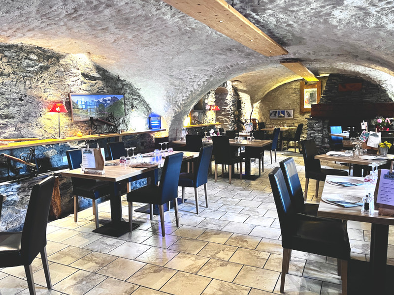 Excellente opportunité situé en face des montagnes, profitez d'une vue imprenable et d'un cadre paisible afin d'acquérir le fonds de commerce de ce restaurant de haute qualité situé sur l'axe principal de la Haute Maurienne en Savoie, suite a raison personnelle,Le restaurant, une ancienne étable rénovée dans un cadre montagnard, est prêt à l'exploitation et peut accueillir une soixantaine de personnes dans deux magnifiques salles voûtées en pierre. À l'extérieur, une terrasse avec pergola pouvant accueillir environ 16 couverts offre une vue imprenable sur les montagnes. Prisé par les fidèles locaux et les touristes en quête d'un très bon restaurant... Un grand appartement lumineux de type T4 en très bon état vient compléter cette offre. 

Plus d'informations et de photos sur demande. 

Depuis le très grand parking, vous montez 12 marches pour arriver sur une terrasse d'environ 50 m² avec pergola d'une capacité d'environ 16 personnes. 5 marches de plus vous mènent à la porte d'entrée principale, mais il est également possible de contourner les escaliers et de rentrer directement dans la salle de restaurant de plain-pied. Vous voilà au bar (licence IV avec permis d'exploitation) avec des tabourets et un petit salon avec des fauteuils et une télévision. La décoration est soignée et bien entretenue avec un carrelage clair, des poutres apparentes, du bois et des pierres. La première salle de restauration, dotée d'une belle cheminée à foyer ouvert offrant un charme incomparable à la pièce, peut accueillir environ 45 personnes. La deuxième salle attenante peut accueillir environ 15 personnes.

Des outils de travail d'exception sont en place :
- une cuisine bien équipée avec du matériel récent et une porte d'accès vers l'extérieur,
- une zone de préparation dessert indépendante de la cuisine,
- un grand bar avec machine à café (sous contrat de location/entretien, le seul contrat attaché à l'exploitation),
- une cave à vin double pour stockage à température idéale de vos vins.

Ce bar-restaurant se trouve dans une petite copropriété de 9 lots, dont 4 qui appartiennent au bail commercial. 
Lot n° 1, étage -1, une cave de 37,7 m² avec entrée extérieure indépendante
Lot n°2, étage 0, le local commercial de 215,5 m²
Lot n°3, étage +1, l'appartement de 118 m² avec pièce de vie orientée sud-est, et une entrée indépendante du restaurant
Lot n°4, étage -1, une cave de 20,1 m² pour stockage du vin, avec accès par la cuisine.

Possibilité d'acquérir les murs immédiatement ou de manière différée.

Fort potentiel de développement : le chiffre d'affaires est établi sur une ouverture uniquement le soir, 6 jours sur 7 pendant la saison d'hiver (mi-décembre à mi-avril) et sur une ouverture a l’ année,


Bilans disponibles sur demande



Pas de démarchage souhaite pour être contacté(e) par des agents immobiliers