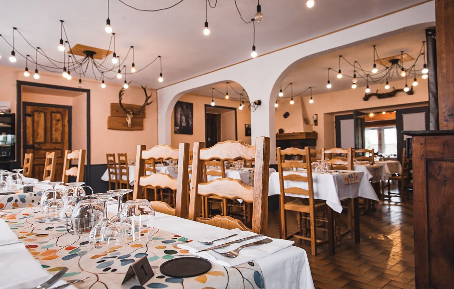 Implanté légèrement en retrait de la route, ce bien bénéficie d'un environnement calme tout en restant au plus proche de la vie du village. Son emplacement privilégié, sa configuration et ses volumes exceptionnels en font un lieu adaptable à de nombreux projets.

Grande maison d'habitation, maison familiale multigénérationnelle, habitat partagé, projet d'accueil, de gîte ou encore reprise d'une activité de restauration existante : les possibilités sont multiples.

Composition de l'ensemble :

Premier bâtiment – environ 550 m² :
Au rez-de-chaussée, un vaste espace d'environ 250 m², aujourd'hui composé de grandes pièces, d'une cuisine et de plusieurs annexes.Ces volumes généreux peuvent être transformés en belles pièces de vie pour une habitation principale ou conservés pour une reprise d'activité de restauration, le fonds pouvant être repris si souhaité.

Au premier étage :
Un appartement de 164 m² comprenant une cuisine, un salon, un bureau, 7 chambres, 2 salles d'eau et 2 WC.Des travaux de rénovation sont à prévoir (menuiseries, isolation, rafraîchissement), offrant une belle liberté d'aménagement selon votre projet.

Au deuxième étage :
Un espace d'environ 135 m², rénové récemment, composé de 6 chambres, d'une pièce commune avec cuisine et d'un espace sanitaire comprenant 3 douches, 2 lavabos et WC.Un niveau idéal pour un logement indépendant, un espace nuit supplémentaire ou un projet d'accueil.

Deuxième bâtiment – environ 141 m² :
Au rez-de-chaussée, deux grands garages de 53 m² et 82 m², équipés de portails électriques et manuels, parfaits pour le stationnement, stockage ou atelier.

À l'étage, deux espaces distincts :
• un appartement rénové de 73 m² comprenant cuisine, salon, 3 chambres, salle de bain et WC,
• un plateau brut de 68 m² à aménager entièrement, idéal pour créer un logement supplémentaire, un bureau ou un espace indépendant.

Extérieurs :
À l'arrière des bâtiments, vous trouverez 4 garages supplémentaires, une grande terrasse à repenser, ainsi qu'un terrain généreux à réaménager selon vos envies : jardin, espace détente ou projet paysager.

Confort et technique :
Le chauffage principal est assuré par une chaudière au fioul, complétée par une cheminée bois pour le bâtiment principal.Les appartements sont équipés de radiateurs électriques.

Cadre de vie et environnement :
Le bien profite d'un cadre de vie authentique, animé par une vraie vie de village.À proximité immédiate : campagne préservée, balades nature, lac du Pechay et lac du Bouchet, très appréciés pour les loisirs et la détente.

En résumé :
Un ensemble immobilier rare par ses volumes, sa modularité et son potentiel, idéal pour un projet de vie ambitieux, qu'il soit résidentiel, familial, collectif ou professionnel, dans un environnement paisible et humain.